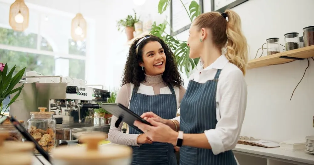 Woman, cafe and employees talking with tablet