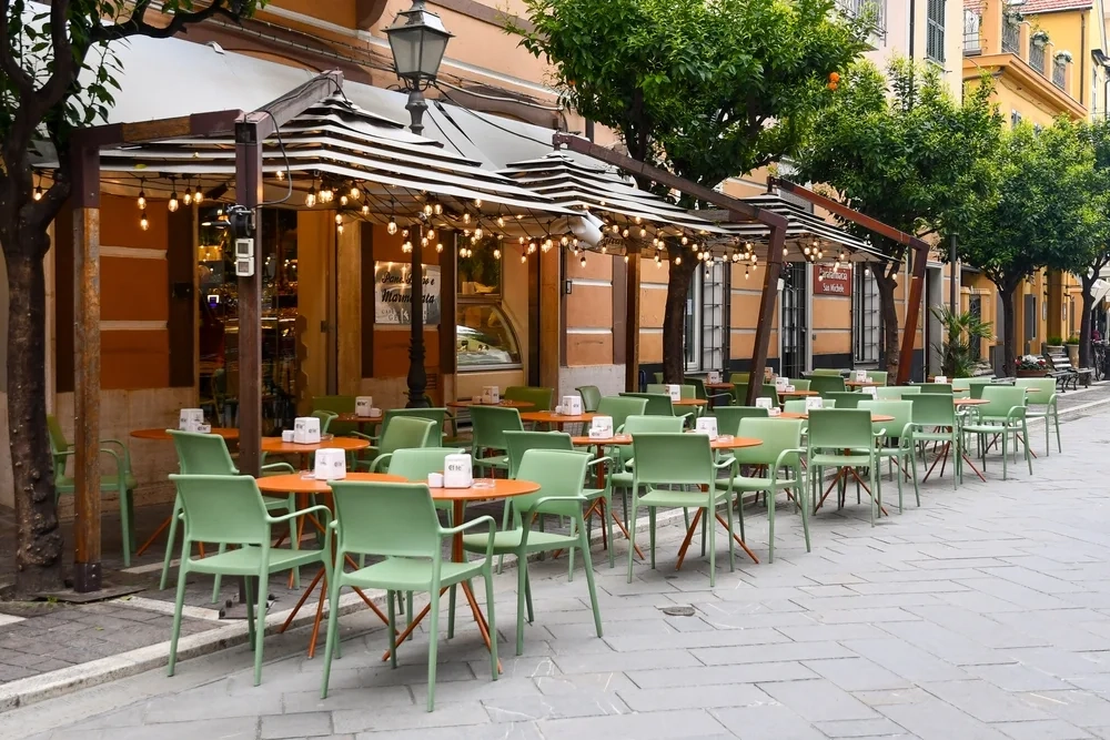 Empty sidewalk cafè with colorful tables and chairs.
