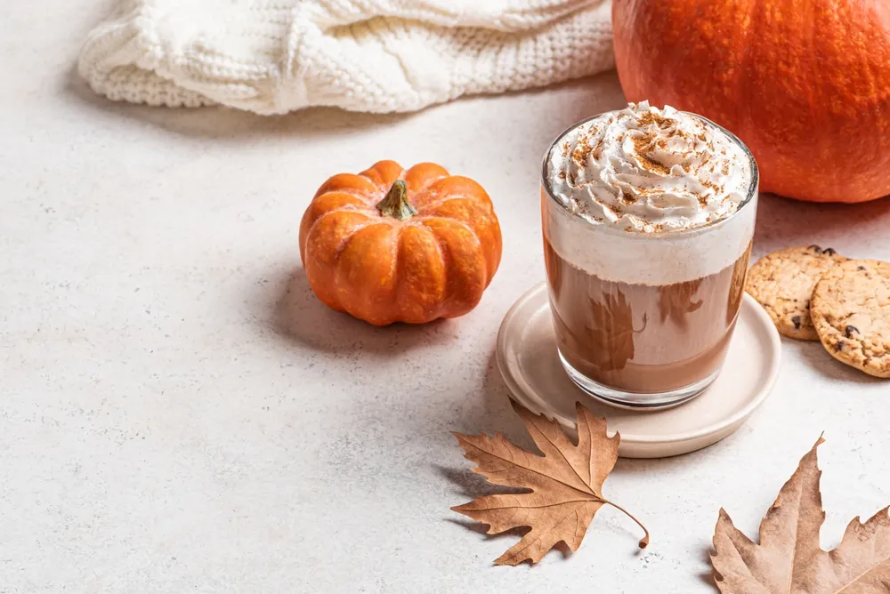 Pumpkin spice latte served in a cafe setting with autumn decor